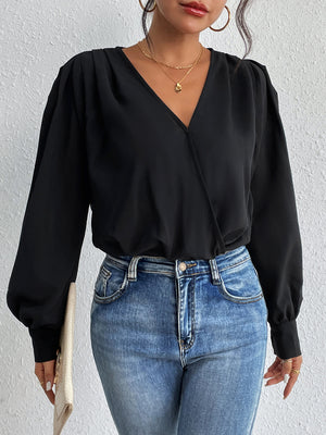 Black balloon sleeve surplice bodysuit with V-neck and cinched cuffs, styled with jeans.