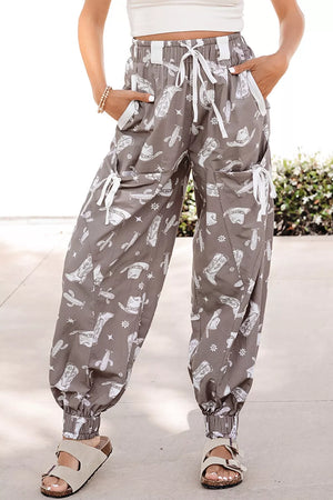 Grey cotton drawstring joggers with white western print, cuffed ankles, and cargo pockets.