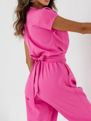 Hot pink wide-leg jumpsuit with short sleeves and a tie waist detail.
