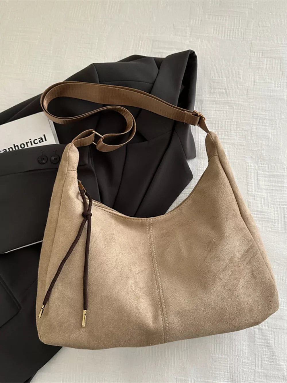 Khaki suede crossbody bag with adjustable strap and drawstring detail