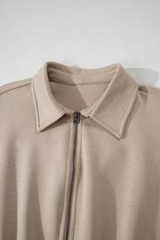 Chic collared zip front romper in beige with cap sleeves.