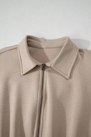 Chic collared zip front romper in beige with cap sleeves.