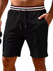 Black textured drawstring shorts with a striped waistband and pockets.