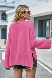 Hot Pink acrylic sweater with flared sleeves and slit hem detail.