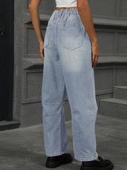Relaxed light wash denim trousers with elastic waist and patchwork detail.