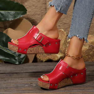 Red open-toe wedge sandals with buckle detail and cork platform.