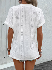 White eyelet V-neck tunic with rolled sleeves and intricate patterned fabric.