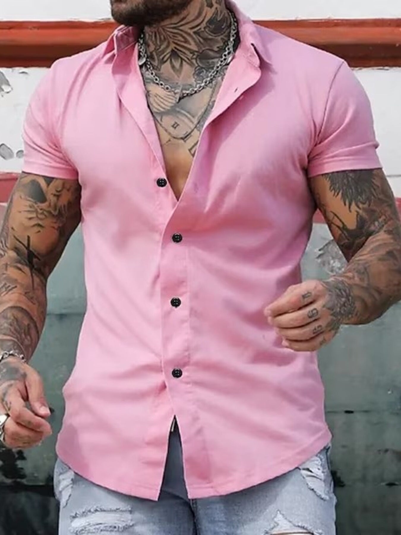 Men's pink slim fit short sleeve button-down shirt with black buttons.