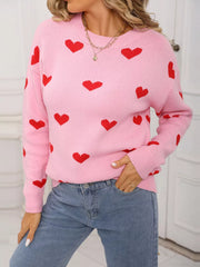 Pink acrylic knit sweater with red heart print, crew neck, and long sleeves.