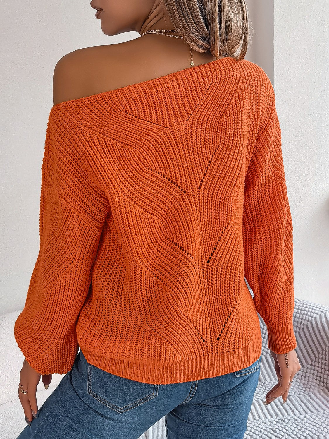 Orange off-the-shoulder knit sweater with openwork detail and relaxed fit.