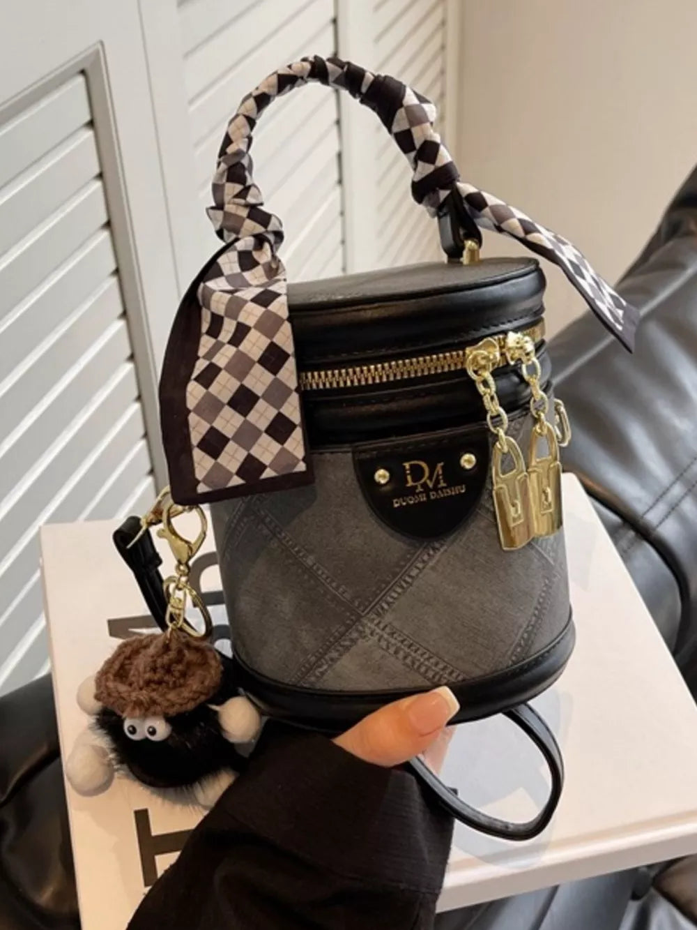 Black quilted mini bucket bag with scarf detail and charm