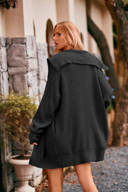 Black oversized hooded knit cardigan with wide collar and ribbed details.