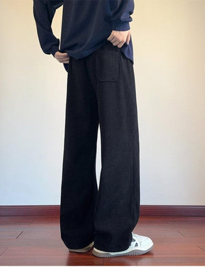 Men's black textured wide leg sweatpants with a back pocket detail.