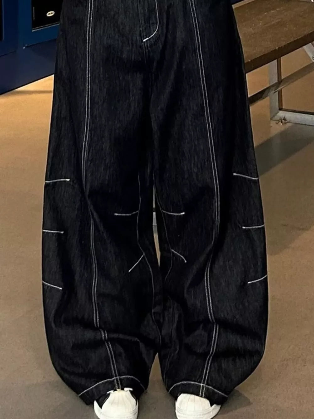 Relaxed fit dark wash denim cargo jeans with contrast stitching and pockets.