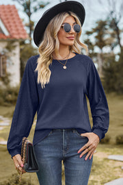 Dark blue waffle knit raglan sleeve top with eyelet detail on sleeves.