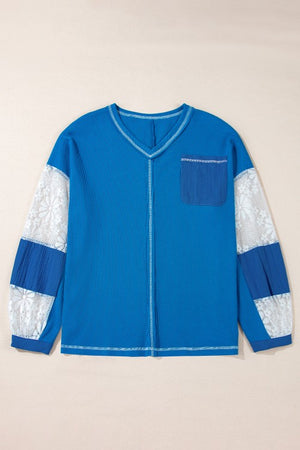 Blue waffle knit top with lace paneled sleeves and chest pocket