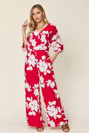 Red floral kimono jumpsuit with wide legs and a tie waist.