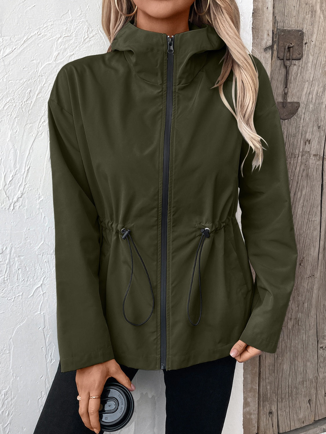 Army green utility jacket with cinched waist, hood, and zipper closure.