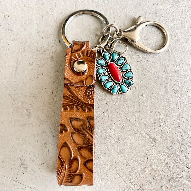 Tooled leather keychain with turquoise and red stone charm.