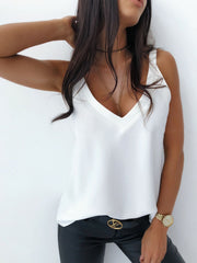 White silky cami top with plunge neckline and layered necklaces.