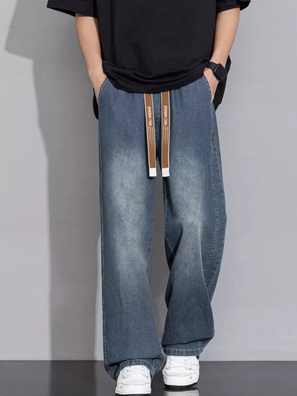 Relaxed vintage wash wide-leg jeans in gray blue with drawstring waist and cotton fabric.
