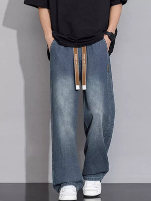 Relaxed vintage wash wide-leg jeans in gray blue with drawstring waist and cotton fabric.