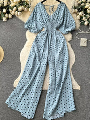 Light Blue polka dot smocked wide-leg romper with puff sleeves and tie back.