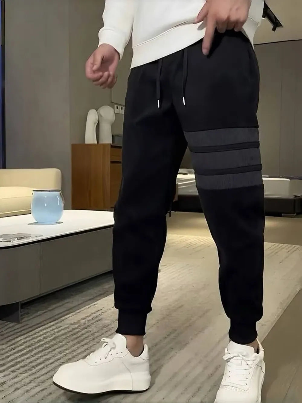 Men's black slim-fit sweatpants with drawstring and triple stripe detail on the leg.