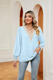 Light blue blouson top with embroidered V-neck trim and cuffs.