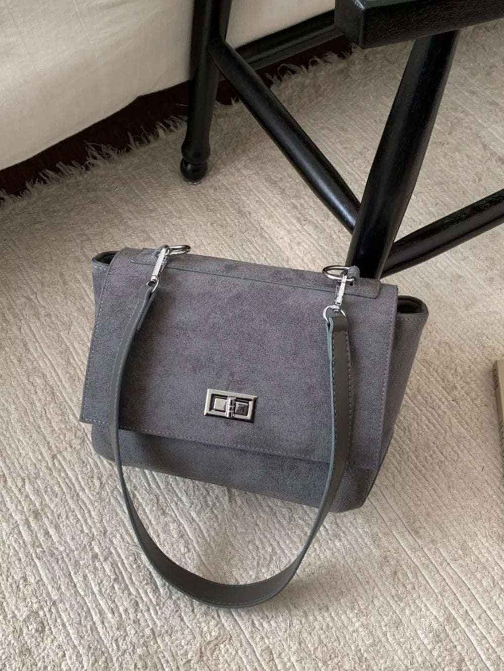 Sleek gray suede crossbody bag with flap closure and silver hardware.