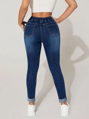 Medium wash denim joggers with elastic drawcord waist and cuffed ankles.