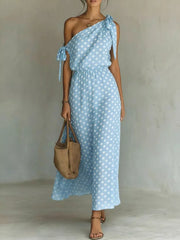 Sky blue polka dot one-shoulder maxi dress with cinched waist and tie details.