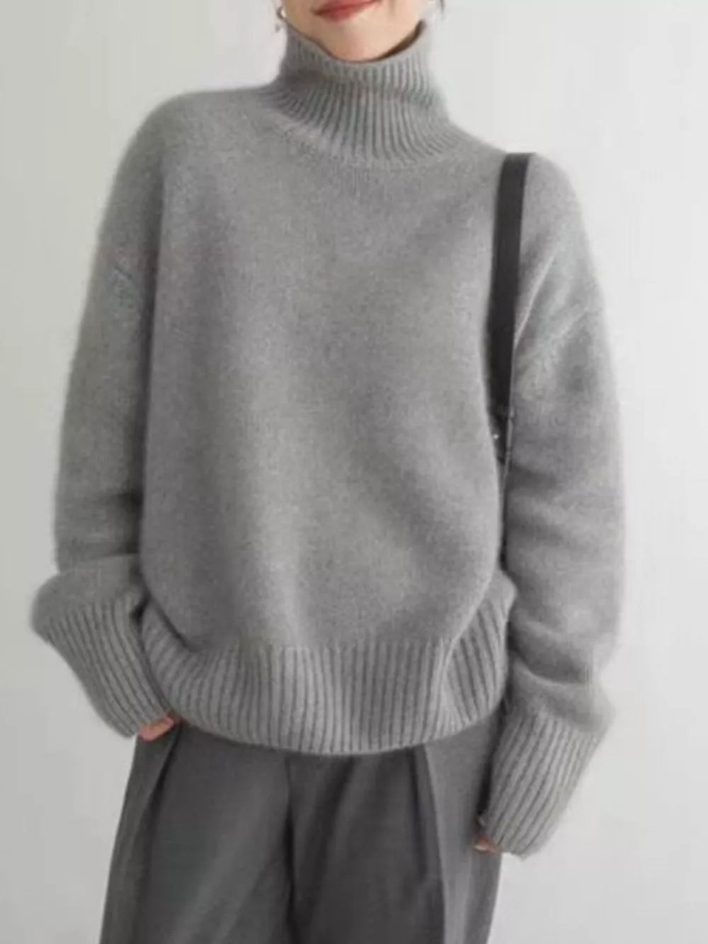 Gray acrylic turtleneck sweater with dropped shoulders and ribbed cuffs and hem.