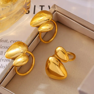 Gold bypass ring with sculptural pebble details, artful and modern design.