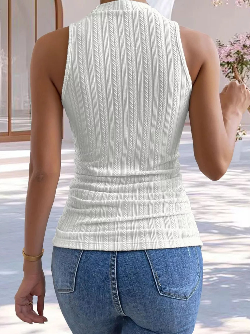 White ribbed mock neck tank top with vertical textured pattern and ruched waist.