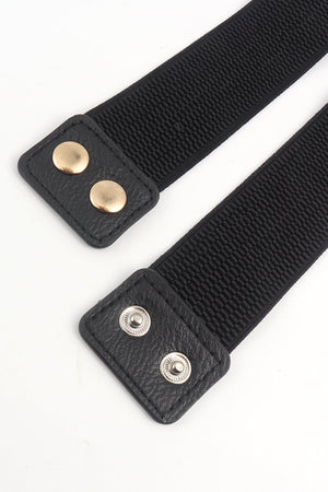 Black elastic belt with faux leather ends and gold and silver snap details