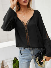 Black lace-inset blouse with tie-neck and slit sleeves.
