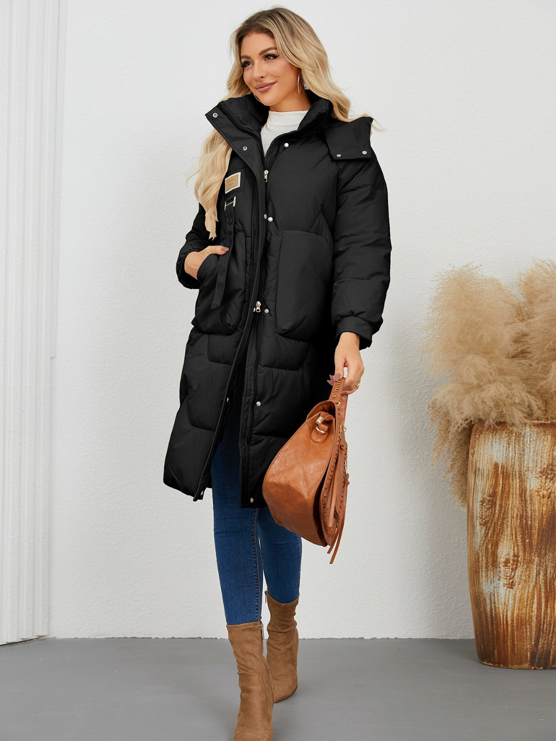 Black quilted puffer parka with hood, buckle detail and large pockets.