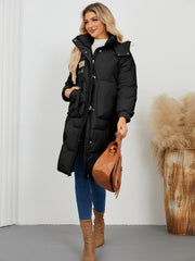 Black quilted puffer parka with hood, buckle detail and large pockets.