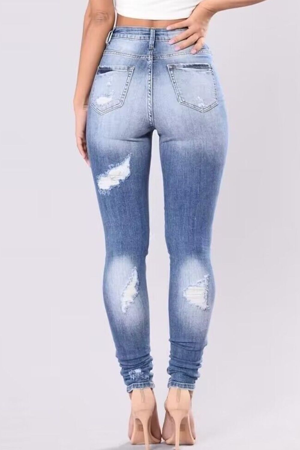 Light wash ripped knee skinny jeans with a sculpting fit.