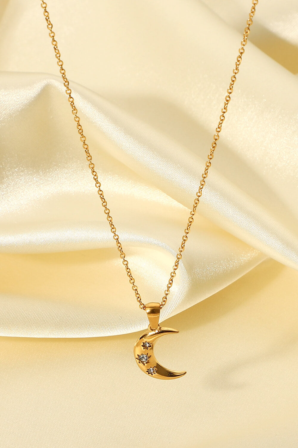 Gold crescent moon pendant necklace with star accents on a delicate chain.
