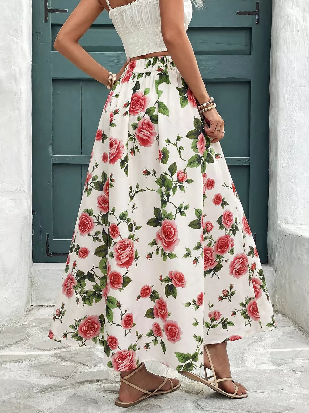 Elegant floral maxi skirt with red roses and green leaves, featuring pleats and a comfortable elastic waist.