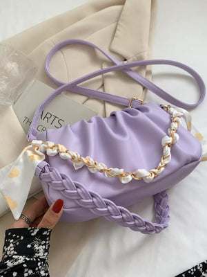 Purple ruched mini shoulder bag with braided strap and chain detail.