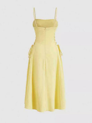 Light yellow cami dress with crisscross lace-up sides and A-line skirt.