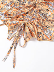 Paisley print halter top in tangerine with ruched detail and tie strings.