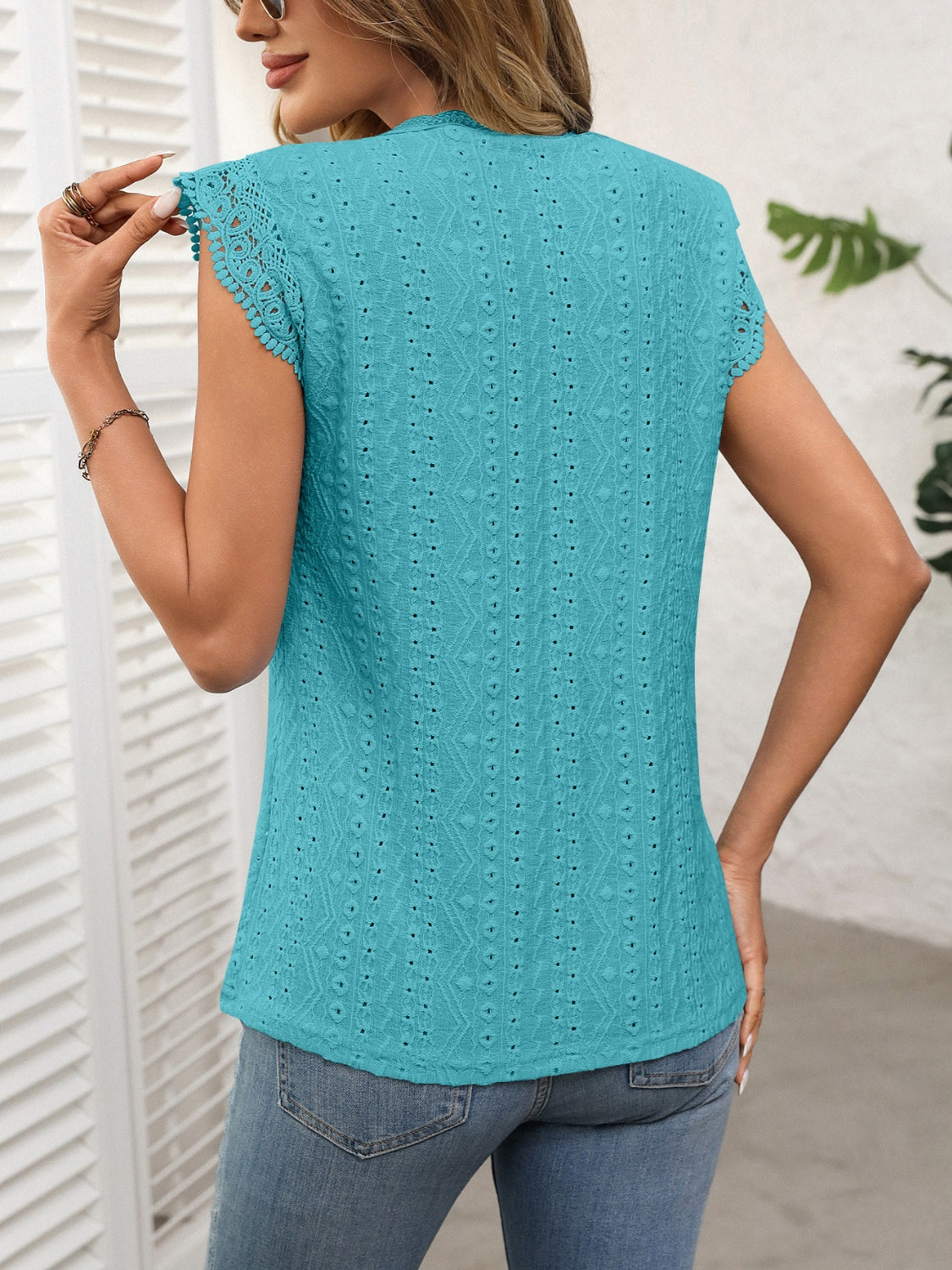 Teal eyelet cap sleeve blouse with textured pattern and lace trim.