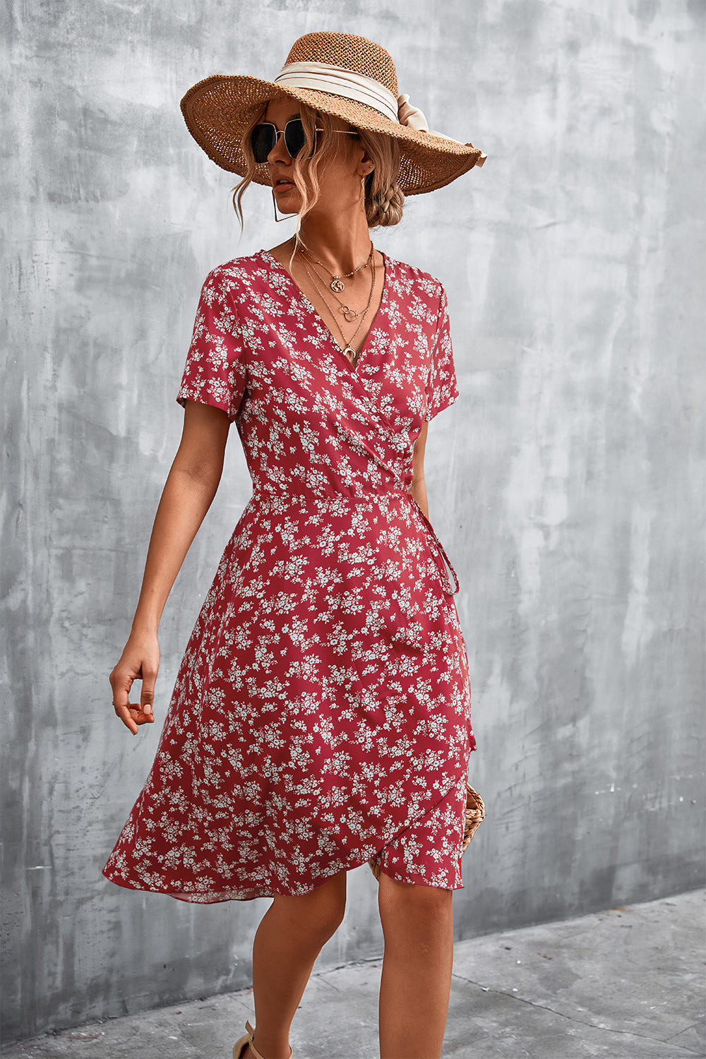 Crimson floral wrap midi dress with short sleeves and v-neck, styled with a straw hat.