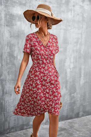 Crimson floral wrap midi dress with short sleeves and v-neck, styled with a straw hat.
