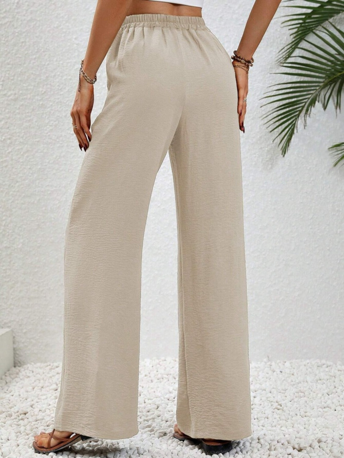 Textured palazzo trousers in cream with a drawstring waist and wide legs.