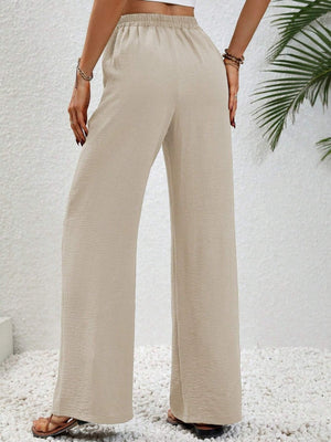 Textured palazzo trousers in cream with a drawstring waist and wide legs.